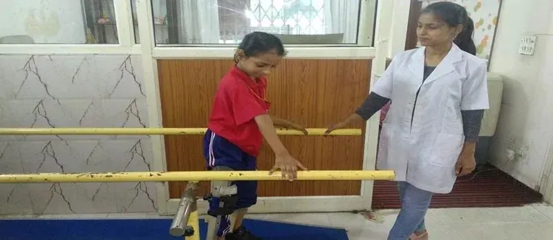 A child practising walking with parallel bars during physiotherapy
